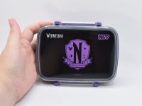 Ланч-бокс Yes Wednesday Nevermore із фіолетовим гербом та ручкою, який тримають у руці для демонстрації компактного розміру. 